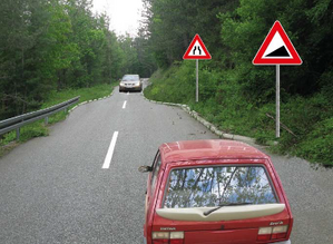 Slika uz pitanje: U situaciji prikazanoj na slici, na delu puta koji je saobraćajnim znakom označen kao opasan uspon odnosno kao opasna n…