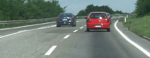 Slika uz pitanje: U situaciji prikazanoj na slici, na putu van naselja vozaču crvenog vozila preticanje vozila u levoj saobraćajnoj traci
