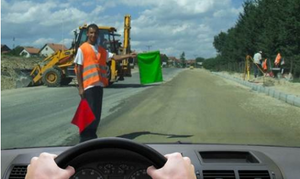 Slika uz pitanje: U situaciji prikazanoj na slici radnik izvođača radova daje znak zastavicom koji označava
