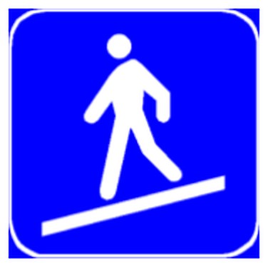 Figura e pyetjes: Sinjali në figurë tregon një plan të pjerrët për kalimin e ngarkesave të rënda në anën tjetër të rrugës.