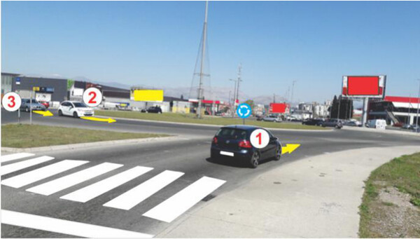 Slika uz pitanje: U raskrsnici sa kružnim tokom saobraćaja, kretanje vozila vrši se: