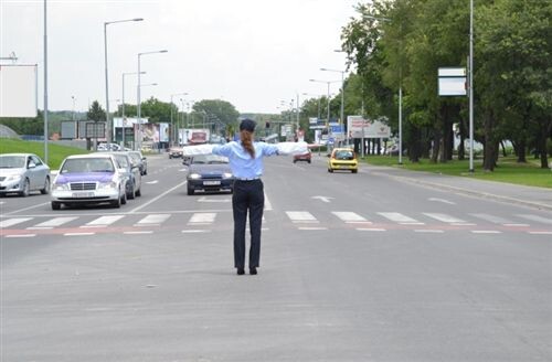 Слика за прашањето: Во случај кога возач на возило на итна помош се доближува кон крстосница на која сообраќајот е регулиран од униформиран…
