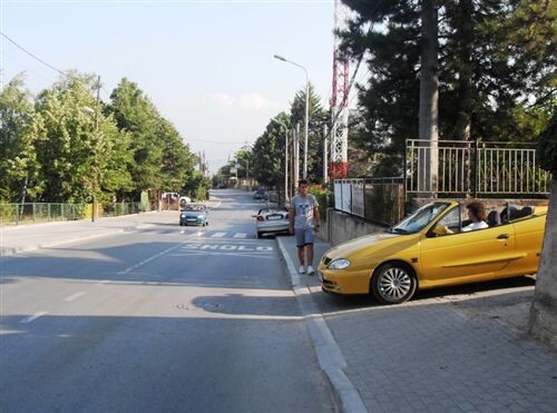 Слика за прашањето: Според ситуацијата прикажана на сликата патничкиот автомобил, прописно се вклучува во сообраќај на пат, ако се движи:
