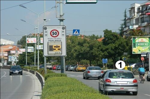 Слика за прашањето: На јавен пат во населено место, возачот на возилото означено со број 1 (како на сликата), се движи:
