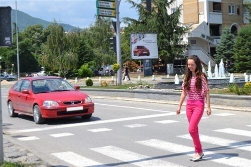 Слика за прашањето: Според ситуацијата како на сликата, возачот на патничкиот автомобил кој се доближува кон пешачкиот премин, должен е: